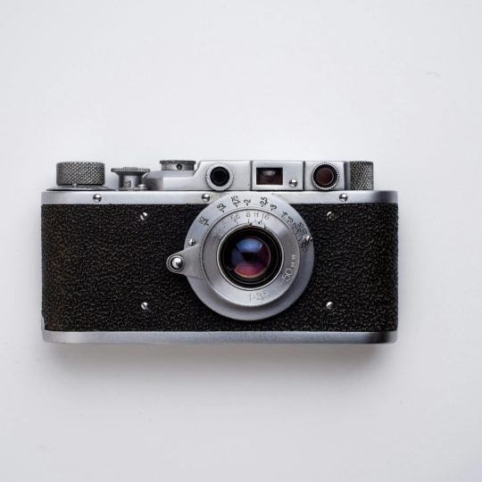 Classic vintage film camera captured in a minimalist flat lay style on a white background.